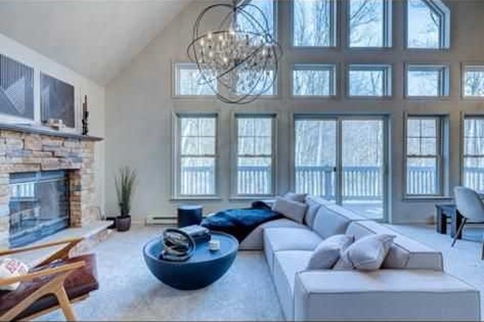 Living room with a stone fireplace and vaulted ceiling, from the Mr. General Services project gallery